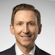 Headshot of a smiling man in a suit