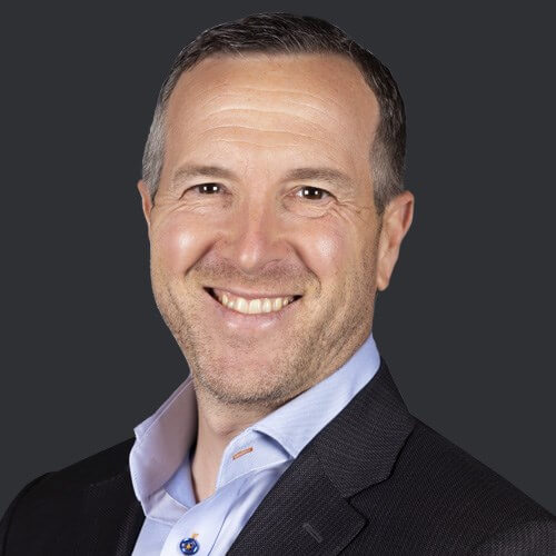 Headshot of Marc Mehlman smiling in a dark suit and light blue shirt
