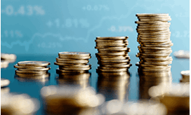 Stacks of coins increasing in height with a rising stock chart in the background