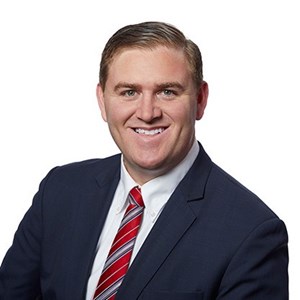 Headshot of Frank Castellvi in a navy suit and red striped tie